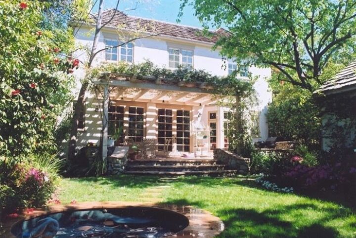 A large white house with a garden in the back.