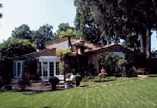 A large brick house with a lawn in front of it.