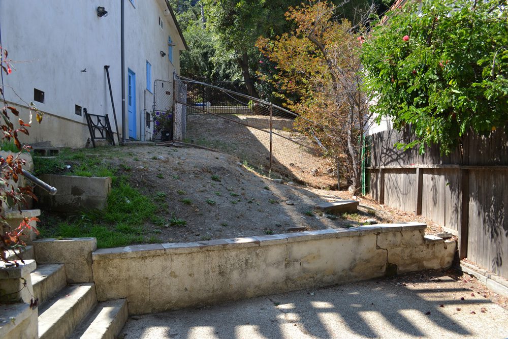 A small hill with a cement wall and steps