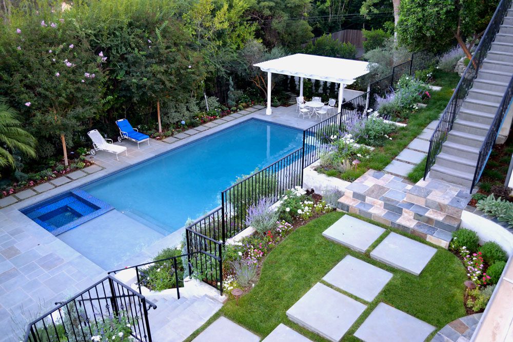 A backyard with an outdoor pool and garden.