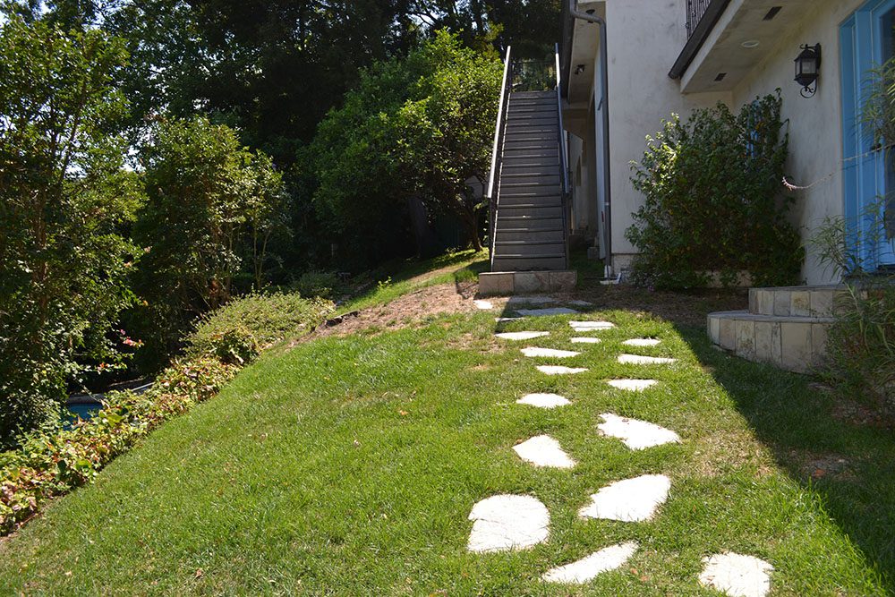 A walkway with stepping stones in the grass.