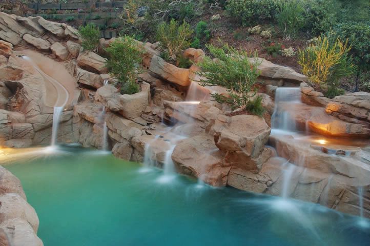 A pool with water flowing over the rocks.