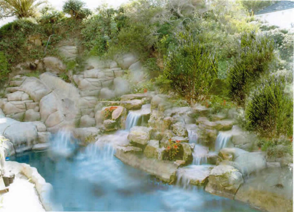 A waterfall with many rocks and trees in the background